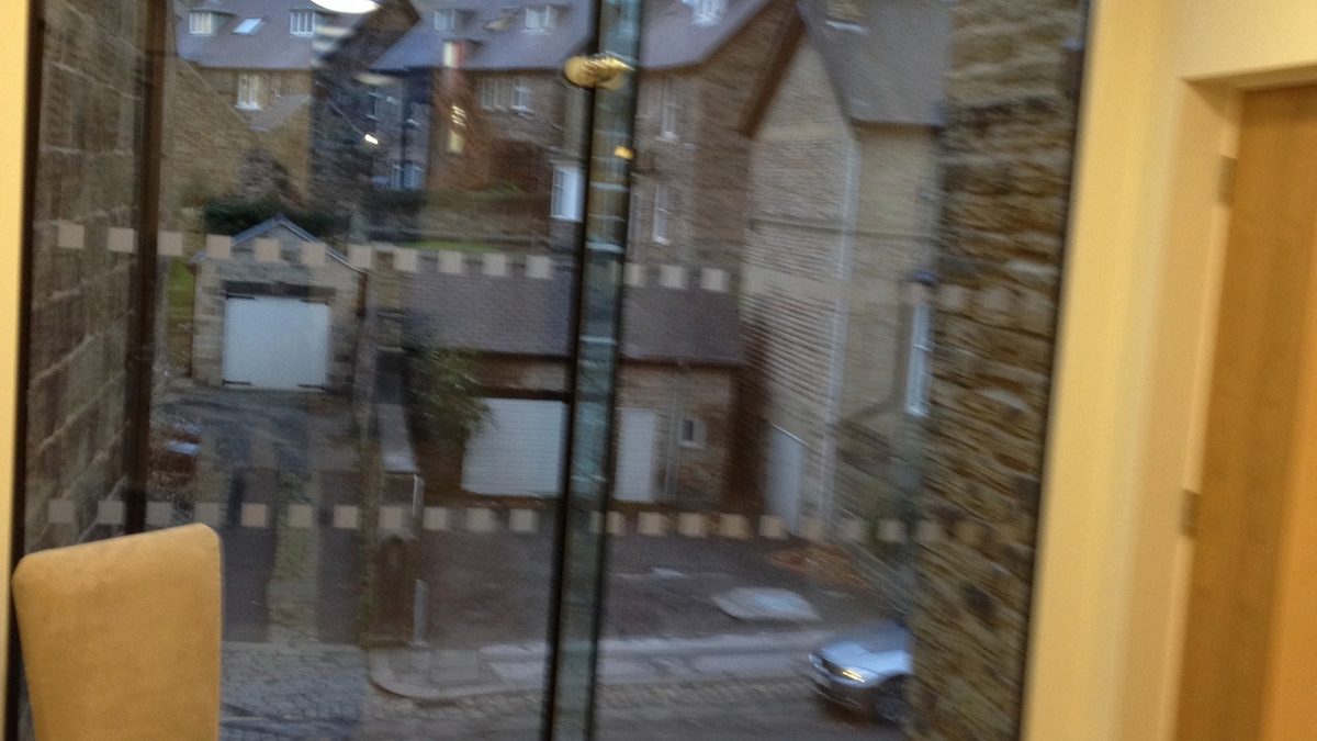 Full-height structural glass façade with point-fixings